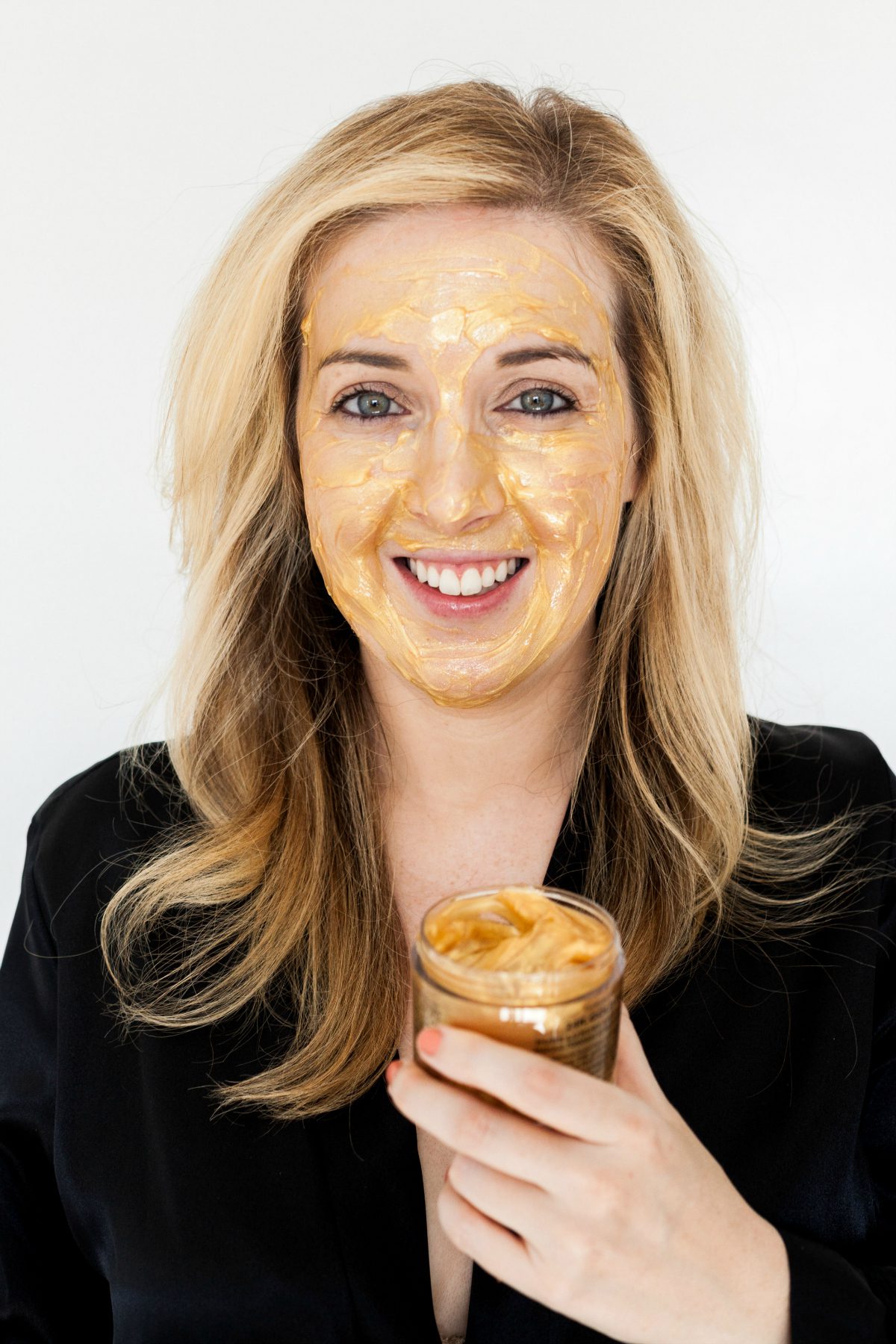 woman holding a tub of Gold Face Mask