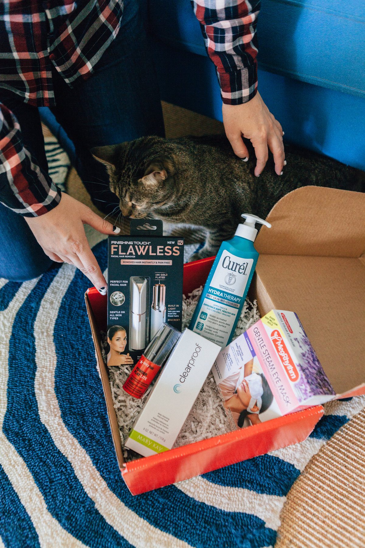 woman with her cat showing products from Red Beauty Box