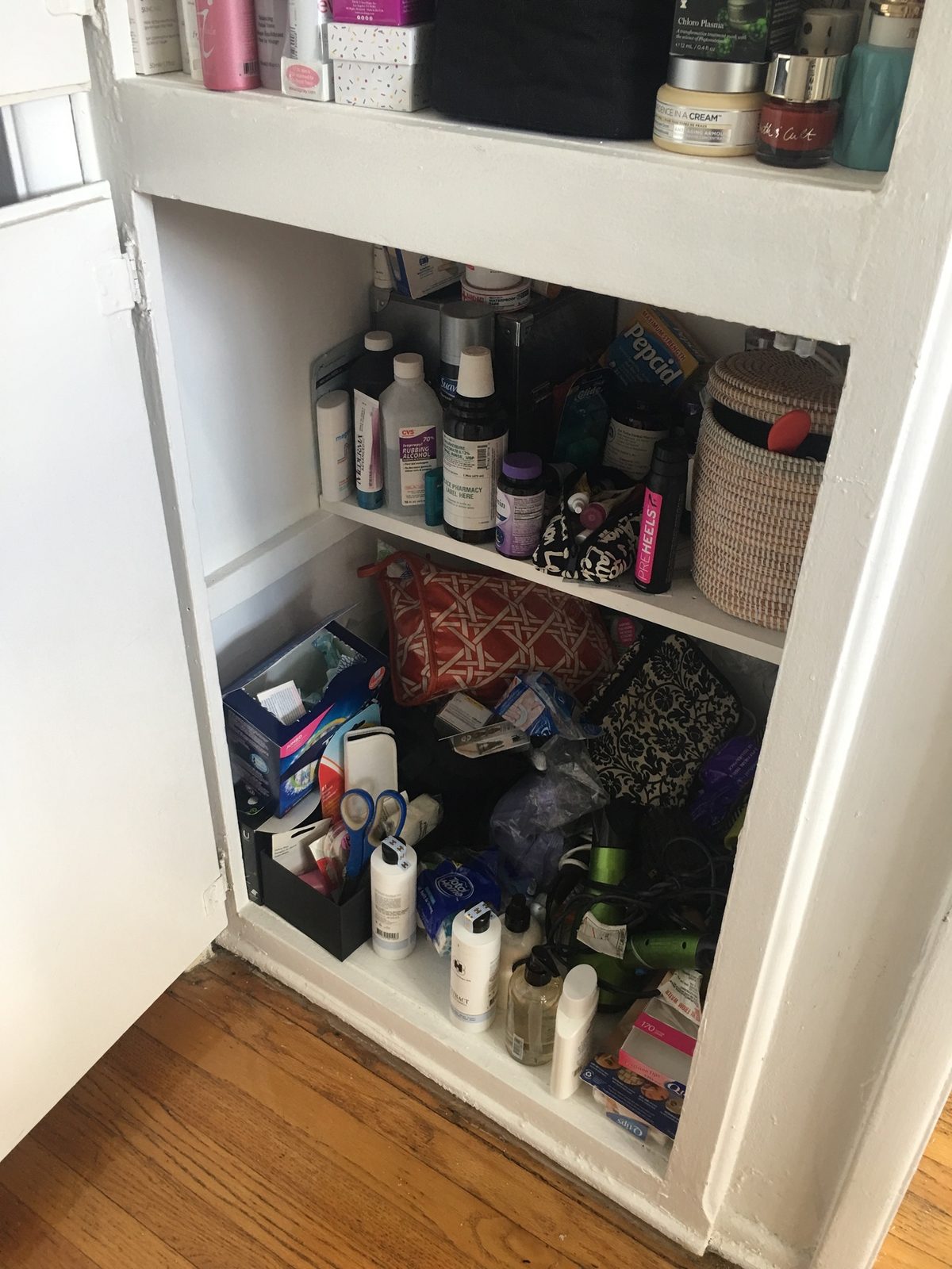 unorganized cabinet with beauty products