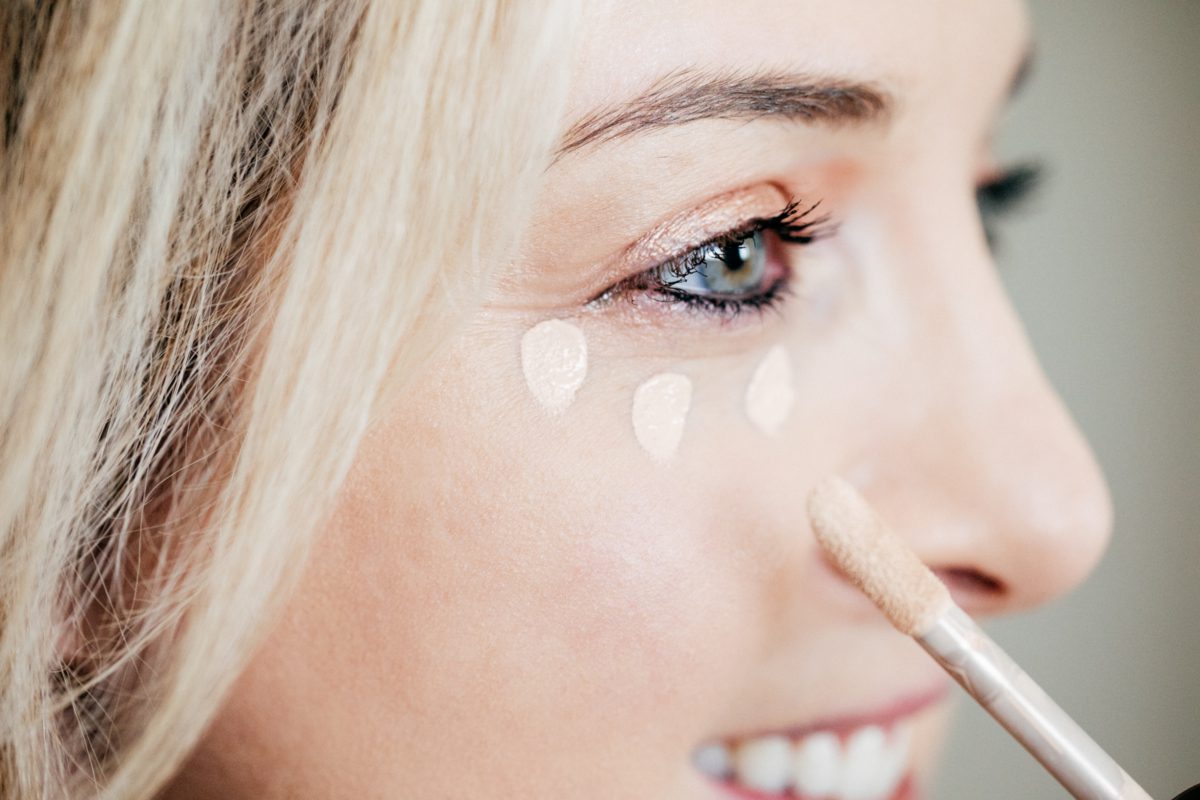 woman applying foundation on face