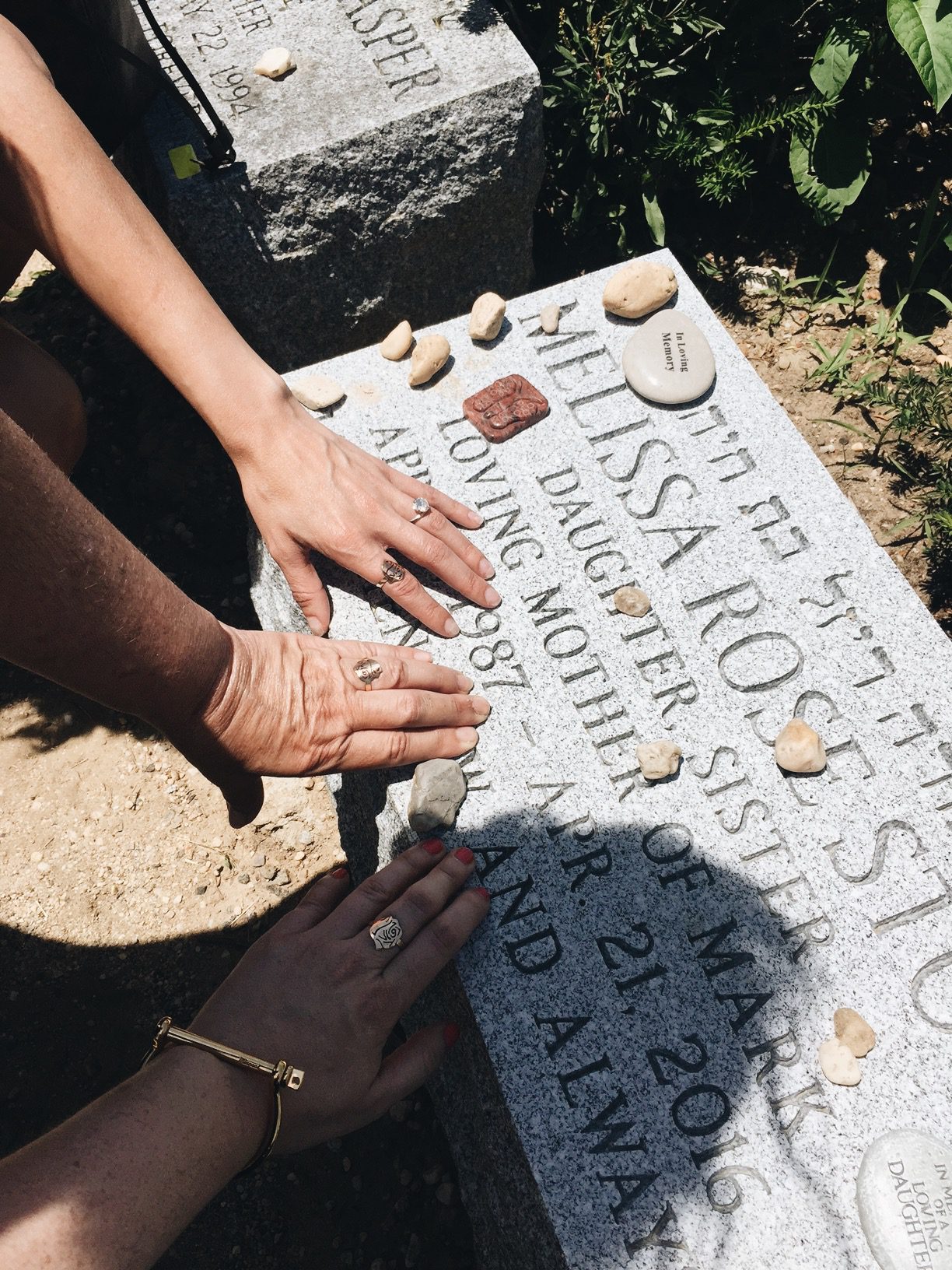 three hands on a grave sharing Sympathy Gift Ideas